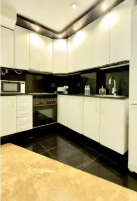 a kitchen with white cabinets and a black floor at Entire Apartment in Barcelona, Camp Nou, Les Corts in Barcelona