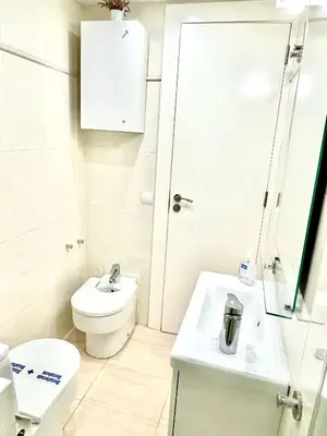 a white bathroom with a toilet and a sink at Sitges Seafront RIBERA in Sitges