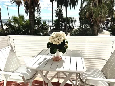 a white table and chairs with a vase of flowers at Sitges Seafront RIBERA in Sitges