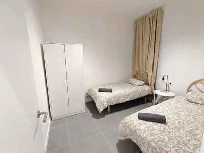 a room with two beds and a cabinet in it at Lovely apartment Poblenou beach in Barcelona