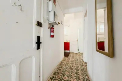 a white bedroom with a bed and a table at Apartamento de 3 habitaciones en Barcelona in Hospitalet de Llobregat