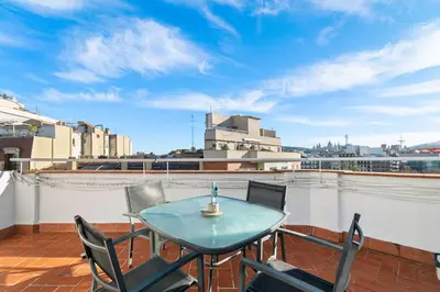 a balcony with a table and chairs on a roof at Downtown penthouse with views of Barcelona in Barcelona