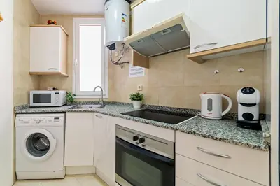 a kitchen with a sink and a washing machine at Downtown penthouse with views of Barcelona in Barcelona