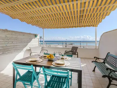 a table and chairs on a balcony with a view of the ocean at Apartment Xaloc by Interhome in Cubelles