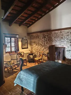 a bedroom with a large bed and a stone wall at Antic Can Poi - Masia histórica del siglo XIII en la Garriga in La Garriga