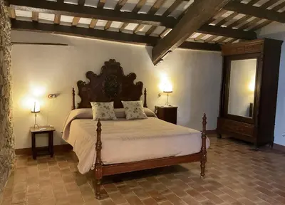 a bedroom with a large bed in a room at Antic Can Poi - Masia histórica del siglo XIII en la Garriga in La Garriga