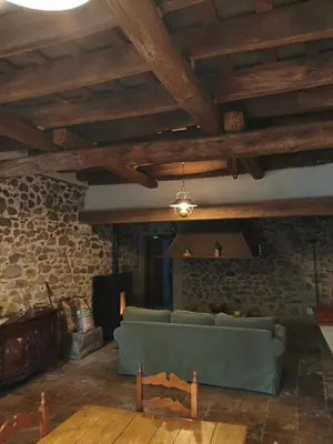 a living room with a couch and a stone wall at Antic Can Poi - Masia histórica del siglo XIII en la Garriga in La Garriga