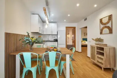 a kitchen and dining room with a wooden table and chairs at BBarcelona Guinardó Park in Barcelona