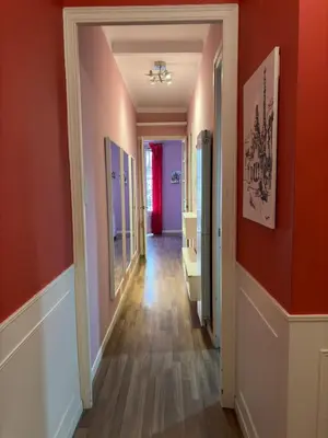 an empty hallway with orange walls and wooden floors at Cozy Apartment in the Center Area Sagrada Familia in Barcelona