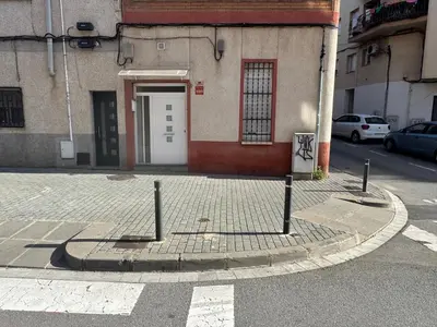 a street with a building with a white door at Habitaciones Carmen in Rubí