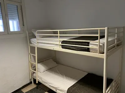a room with two bunk beds and a window at Habitaciones Carmen in Rubí