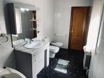 a white bathroom with a sink and a toilet at Habitaciones Carmen in Rubí