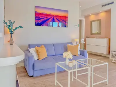 a living room with a blue couch and a table at Bonaire Penthouse Sitges 2 terraces steps from beach in Sitges