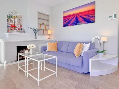 a living room with a blue couch and a table at Bonaire Penthouse Sitges 2 terraces steps from beach in Sitges