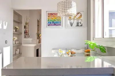 a kitchen with a white counter and a pendant light at Bonaire Penthouse Sitges 2 terraces steps from beach in Sitges