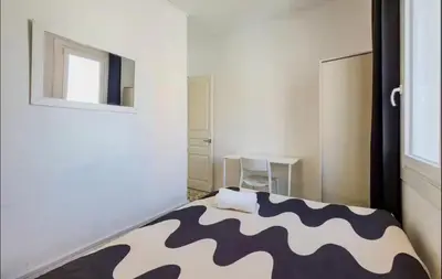 a bedroom with two beds and a fan in it at Cozy apartment in bcn 3 bedrooms in Hospitalet de Llobregat