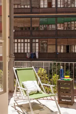 a chair on a patio with a building in the background at Catalan Music Palace with private terrace in Barcelona