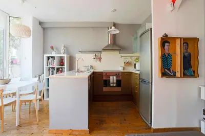 a kitchen with a refrigerator and a table in a room at Barcelona Attic center 2 Terraces Magic views in Barcelona