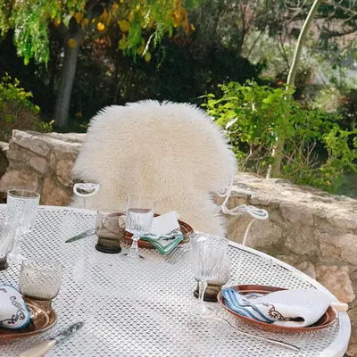a cat sitting at a table with a table cloth at Masia Can Pares in Sant Pere de Ribes