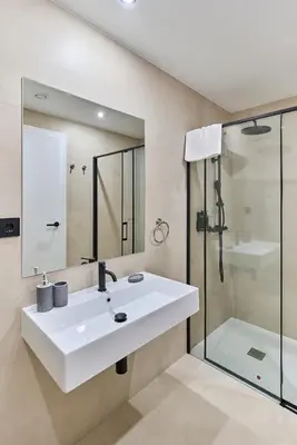 a bathroom with a white sink and a shower at Sant Adrià Urban Suites by gaiarooms in Badalona