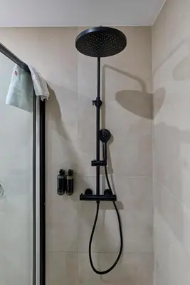 a shower with a shower head in a bathroom at Sant Adrià Urban Suites by gaiarooms in Badalona