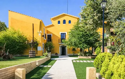 a yellow house with a pathway in front of it at Gorgeous Home In Olerdola With Private Swimming Pool, Can Be Inside Or Outside in Olerdola