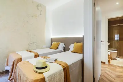 a room with two beds with a hat on them at En Ville Boutique Apartments Boqueria Market in Barcelona