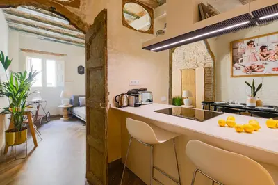 a kitchen with a counter and chairs in a room at En Ville Boutique Apartments Boqueria Market in Barcelona