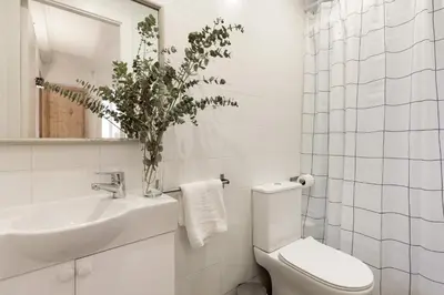a white bathroom with a toilet and a sink at Enjoy Apartments VP Camp Nou 1 in Barcelona