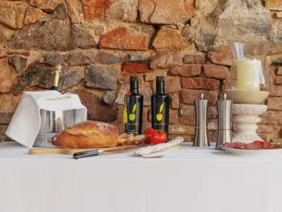 a table with bread and bottles of wine and cheese at Apartment Superior-Doppelsuite mit Schlafsofa by Interhome in Bigues i Riells