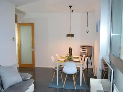 a dining room with a table and chairs and a couch at Holiday Home Haus Terrassa de Mar direkt am Strand by Interhome in Masnou