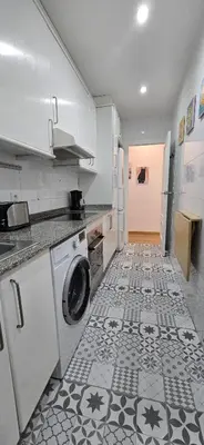 a kitchen with a washing machine and a tile floor at 2-bedroom Bright and Classic Sagrada Familia Apartment in Barcelona