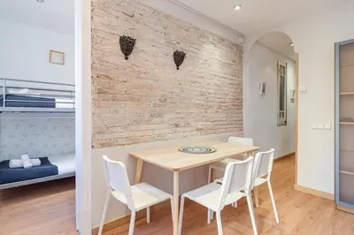 a dining room with a table and white chairs at 2-bedroom Bright and Classic Sagrada Familia Apartment in Barcelona