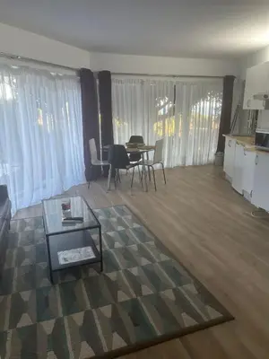 a living room with a table and chairs and curtains at Las Buganvillas in Castelldefels