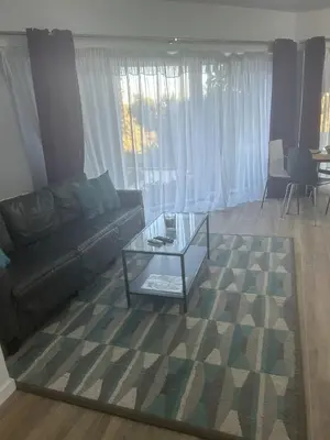 a living room with a couch and a glass coffee table at Las Buganvillas in Castelldefels