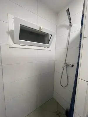 a shower in a white bathroom with a window at Private room next to BCN airport in El Prat de Llobregat