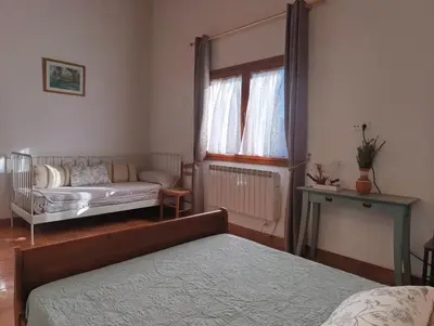 a bedroom with two beds and a window at Masía Can Janàs in Lliçà d'Amunt