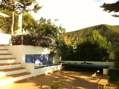 a kitchen with white cabinets and a television on the wall at Independ room in villa with views 2 in Castelldefels