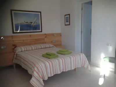 a bedroom with a bed with two green towels on it at Independent Room in private villa with view1 in Castelldefels