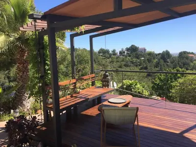 a wooden deck with a table and chairs on it at Independent Room in private villa with view1 in Castelldefels