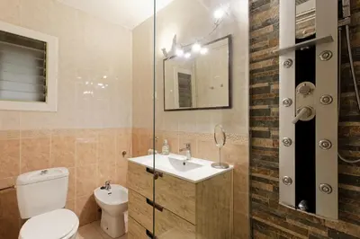 a bathroom with a toilet and a sink and a mirror at Fantastic Penthouse in Barcelona