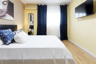a bedroom with a white bed with a flat screen tv at Fantastic Penthouse in Barcelona