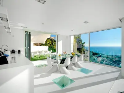 a white dining room with a glass table and chairs at Villa in Sitges with Pool, Jacuzzi, BBQ, View, AC, 12Pax in Sitges