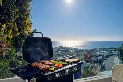a grill with food on it with a view of the ocean at Villa in Sitges with Pool, Jacuzzi, BBQ, View, AC, 12Pax in Sitges