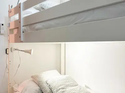 a bedroom with two bunk beds and a lamp at Apartment Iolanda in Vilanova i la Geltrú