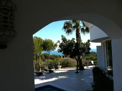 an archway with a palm tree in a house at Suite in private villa view on sea in Castelldefels