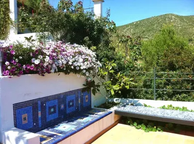a balcony with flowers on the side of a building at Suite in private villa view on sea in Castelldefels