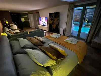 a large bed with pillows on it in a living room at SuitePoolBarcelona in Vilassar de Dalt