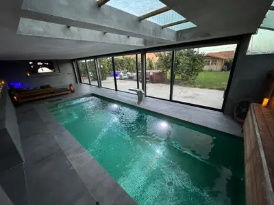 an indoor swimming pool with green water in a house at SuitePoolBarcelona in Vilassar de Dalt