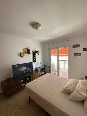 a bedroom with a large bed and a flat screen tv at Maresme in Canet de Mar